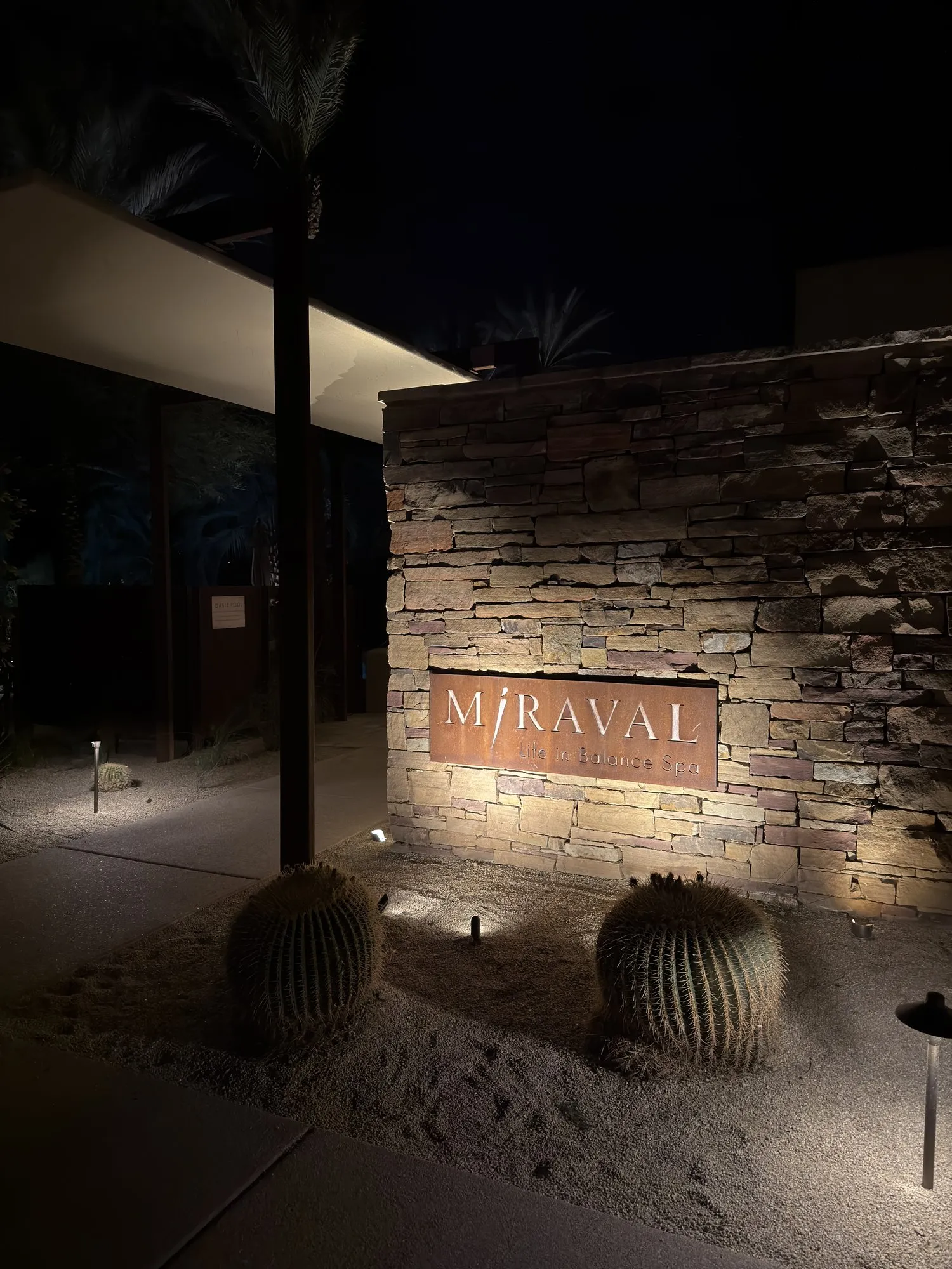 夜晚的 Miraval 石墙门牌,暖色灯光下的仙人掌